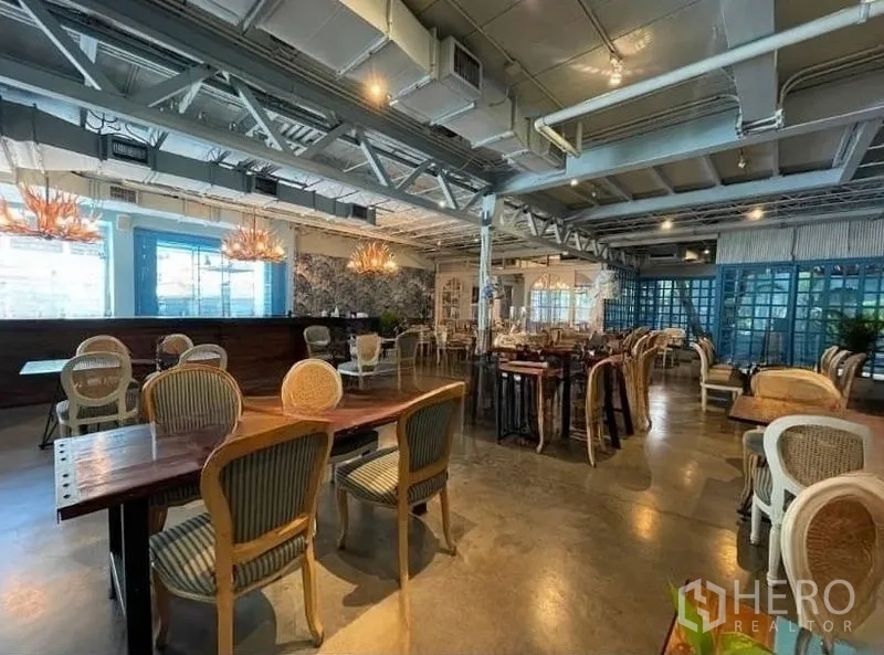 零售空间 出租在Watthana, Bangkok - 宽敞的餐饮式室内空间，外露天花与木桌椅