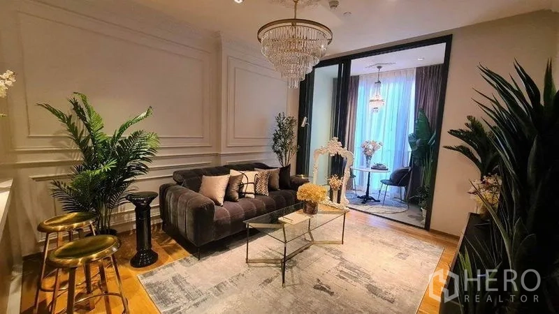 คอนโด ให้เช่าในKhlong Toei, Bangkok - ห้องนั่งเล่นหรู โคมแชนเดอเลียร์ โซฟากำมะหยี่ โต๊ะกระจก และต้นไม้ในอาคาร