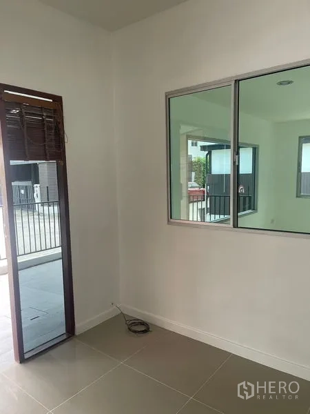 Townhouse for sale - Bright ground-floor room with tiled flooring and window facing the patio