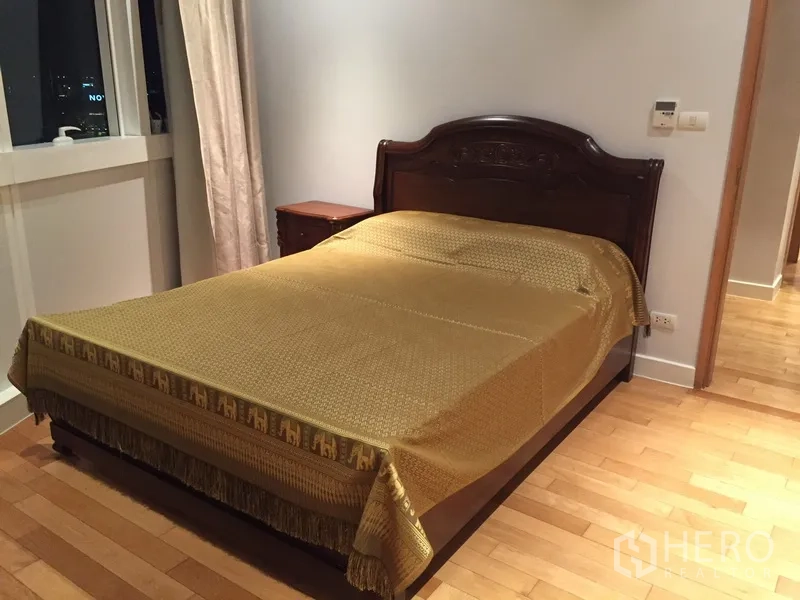 คอนโด ให้เช่าในKhlong Toei, Bangkok - ห้องนอนอบอุ่น เตียงไม้สีเข้ม ปูผ้าคลุมเตียงสีทอง มีหน้าต่างและโต๊ะข้างเตียง