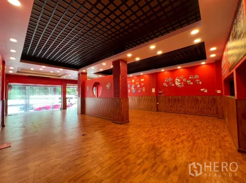 อาคารพาณิชย์ ให้เช่าในWatthana, Bangkok - ฮอลล์ค้าปลีกชั้นล่างกว้าง พื้นไม้ ผนังสีแดง เพดานตะแกรงพร้อมไฟ