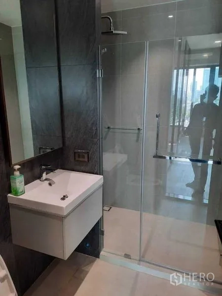 公寓 出租或出售在Phaya Thai, Bangkok - 现代浴室，玻璃淋浴房与壁挂式洗手台。