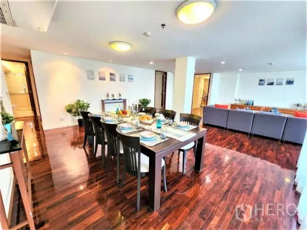 Condominium for rent in Bang Rak, Bangkok - Formal dining zone beside the lounge, table set for eight and expansive glazing.