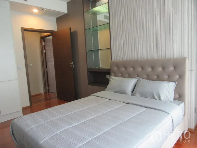 公寓 出租或出售在Watthana, Bangkok - 次卧配软包床头与内置玻璃展示架。