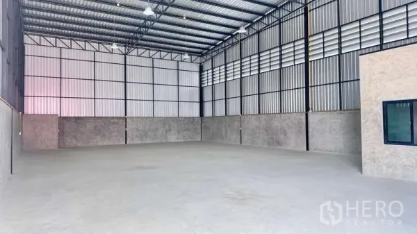 货栈 出租在Khlong Sam Wa, Bangkok - 开阔无柱仓库内部，高屋顶、照明充足与半高混凝土墙面。