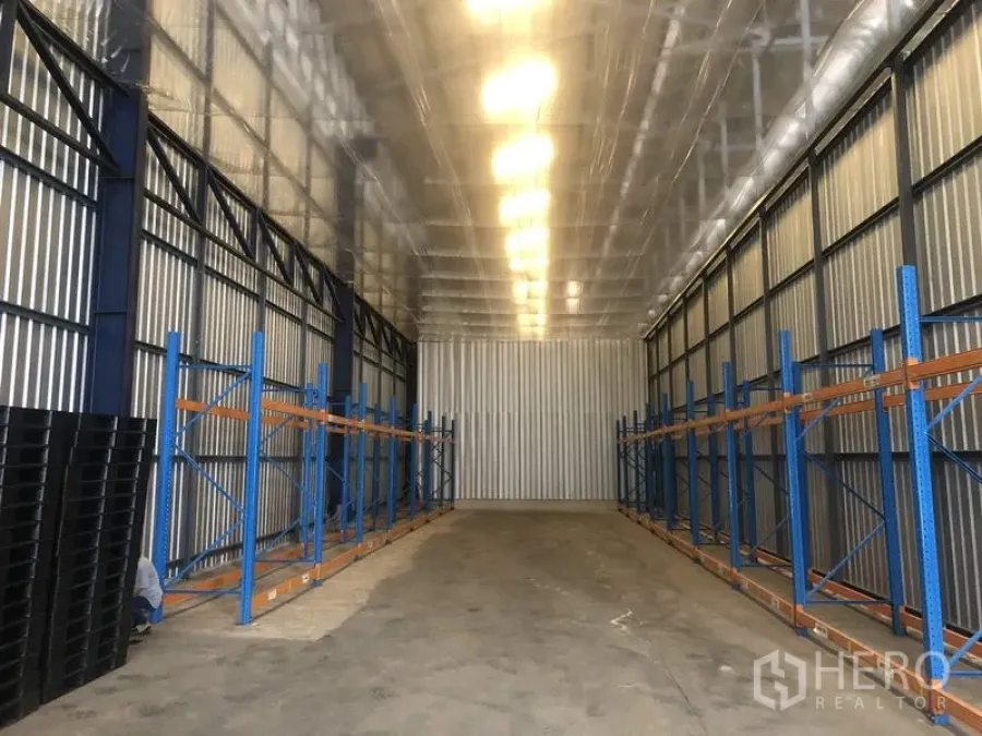 คลังสินค้า ให้เช่าในPak Kret, Nonthaburi - โถงโกดังเพดานสูงพร้อมชั้นวางเหล็กสีน้ำเงินและหลังคากันความร้อน ในปากเกร็ด นนทบุรี