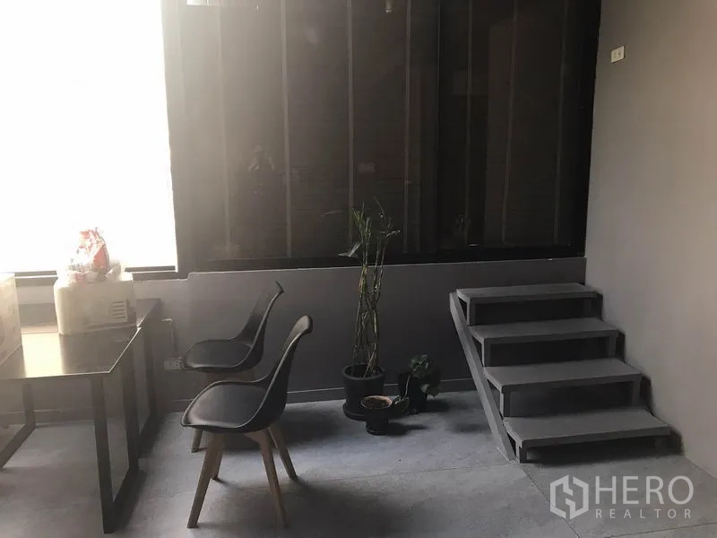 พื้นที่ขายปลีก ให้เช่าในWatthana, Bangkok - มุมนั่งรอขนาดเล็ก เก้าอี้สองตัว โต๊ะทำงาน กระถางต้นไม้ และบันไดเตี้ย