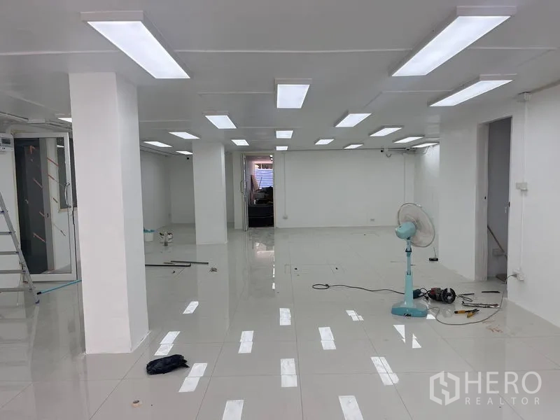 零售空间 出租在Khlong Toei, Bangkok - 开放空间，明亮LED灯，装修中地面有工具。
