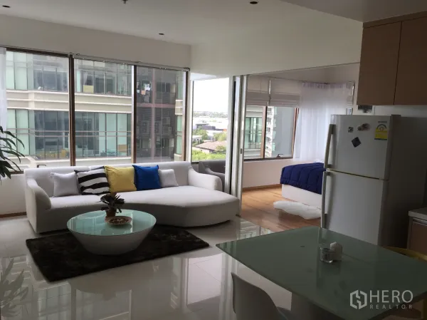 คอนโด ให้เช่าในKhlong Toei, Bangkok - ห้องนั่งเล่นแบบโอเพ่นพร้อมโซฟาสีขาว โต๊ะกระจก มุมทานข้าว และหน้าต่างบานใหญ่เห็นวิวเมือง