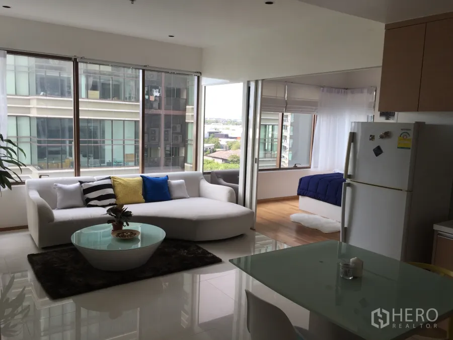 คอนโด ให้เช่าในKhlong Toei, Bangkok - ห้องนั่งเล่นแบบโอเพ่นพร้อมโซฟาสีขาว โต๊ะกระจก มุมทานข้าว และหน้าต่างบานใหญ่เห็นวิวเมือง