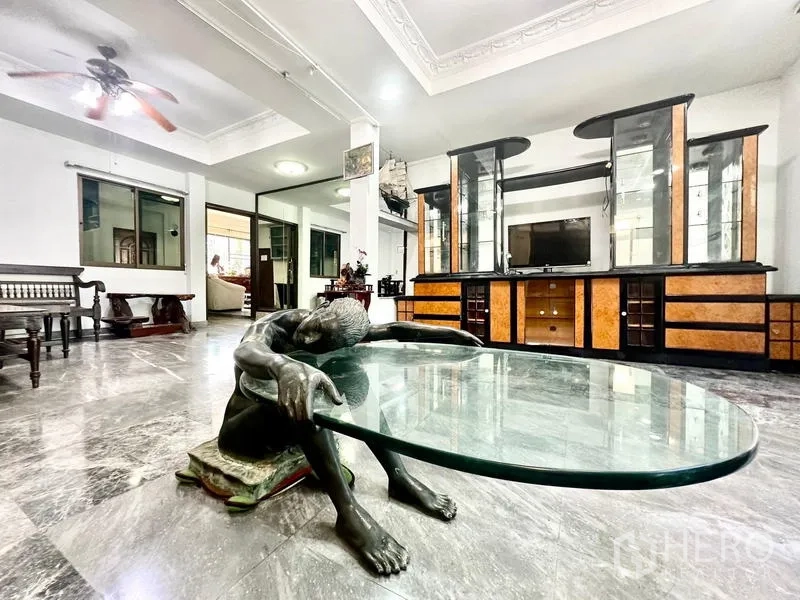 บ้าน ให้เช่าในTaling Chan, Bangkok - โต๊ะกลางกระจกฐานประติมากรรมในห้องนั่งเล่นกว้าง พร้อมตู้วางทีวี.