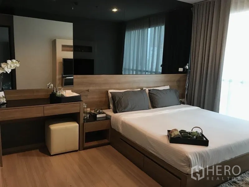 公寓 出租在Sathon, Bangkok - 温馨主卧，木质床头、梳妆台、大窗与全落地窗帘。