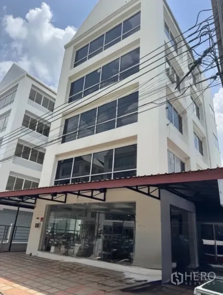 สำนักงาน ให้เช่าในBueng Kum, Bangkok - อาคารสำนักงานสีขาวสูง 6 ชั้น หน้าต่างกระจกบานใหญ่และทางเข้าโชว์รูมชั้นล่าง