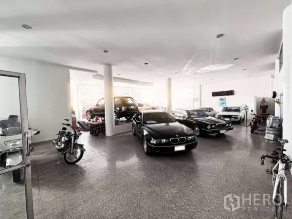展厅 出租或出售在Bangkok Yai, Bangkok - 明亮的室内展厅，陈列多辆汽车与摩托车，白色立柱与自然采光。