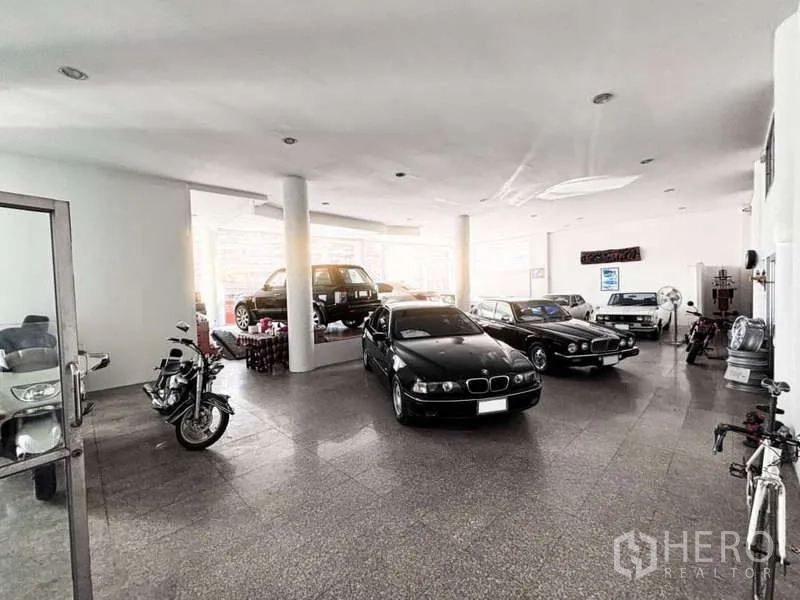 展厅 出租或出售在Bangkok Yai, Bangkok - 明亮的室内展厅，陈列多辆汽车与摩托车，白色立柱与自然采光。