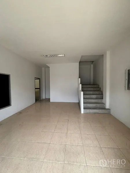 Warehouse for rent in Phra Samut Chedi, Samut Prakan - Ground-floor office area with stairs to the mezzanine and tiled flooring.