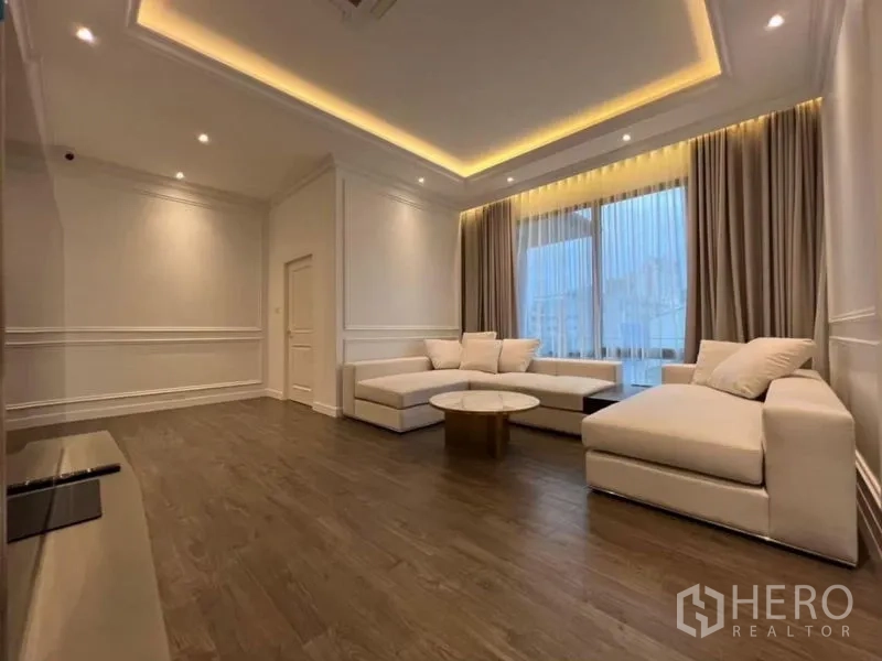 Detached House for rent - Spacious lounge with sectional sofa, wood floors and recessed ceiling lights.