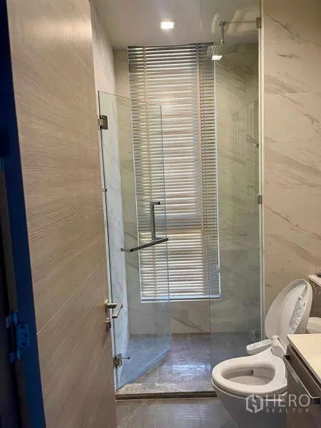 Condominium for rent - Contemporary bathroom with glass-enclosed shower and toilet.