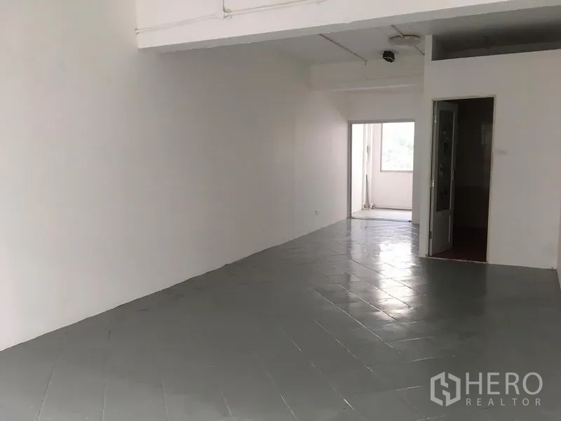 อาคารพาณิชย์ ให้เช่าในKhlong Toei, Bangkok - ชั้นบนปูพื้นกระเบื้องสีเทา ผนังสีขาว และประตูเชื่อมพื้นที่ระเบียงเล็ก