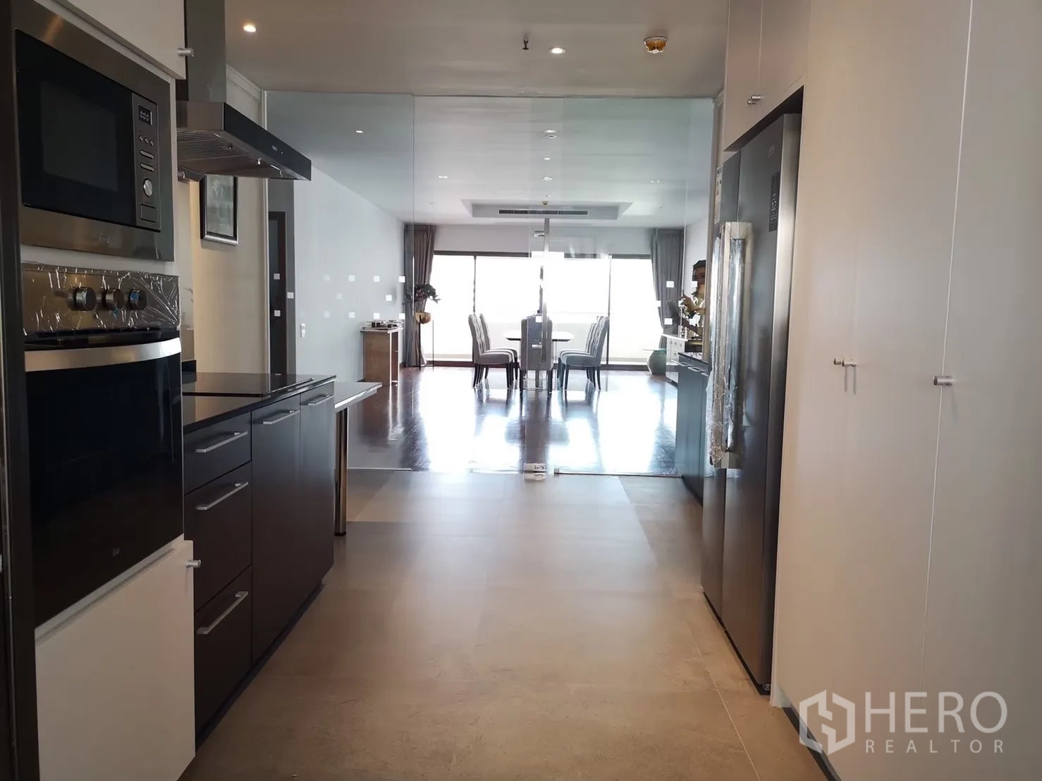 คอนโด ให้เช่าในBangkok - ครัวแบบแกลเลอรี่ยาว เตาอบบิลท์อินและตู้เย็นใหญ่ เชื่อมสู่ห้องอาหาร