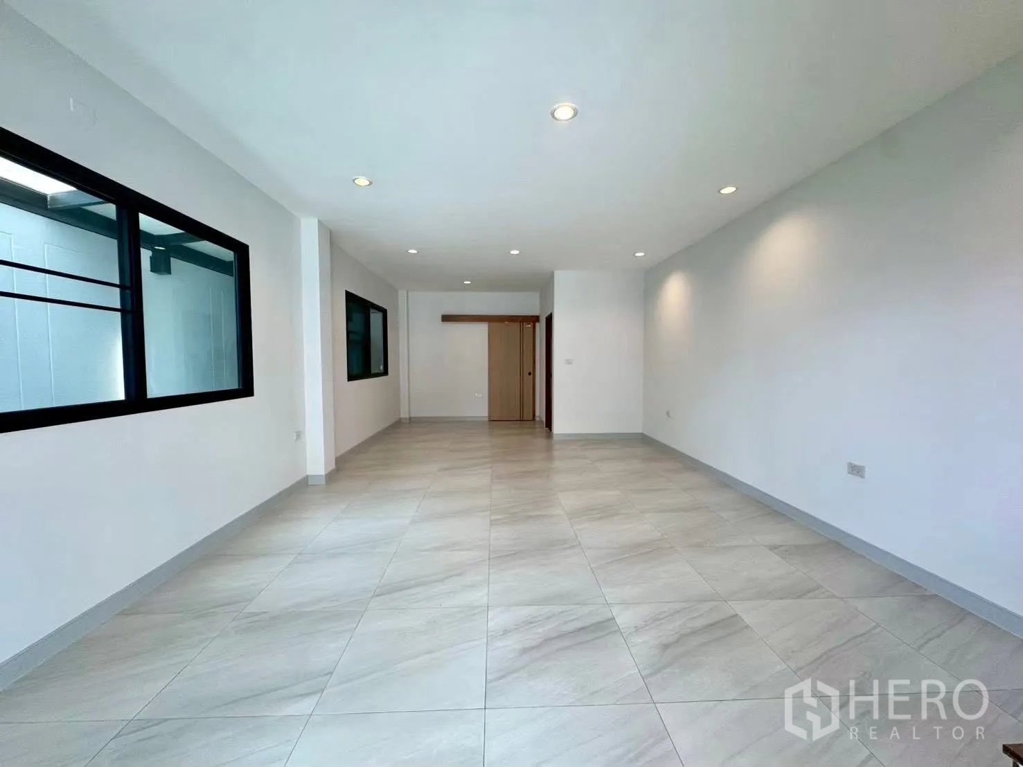 Home Office for rent in Wang Thonglang, Bangkok - Long open-plan ground floor with large windows and door at the end.