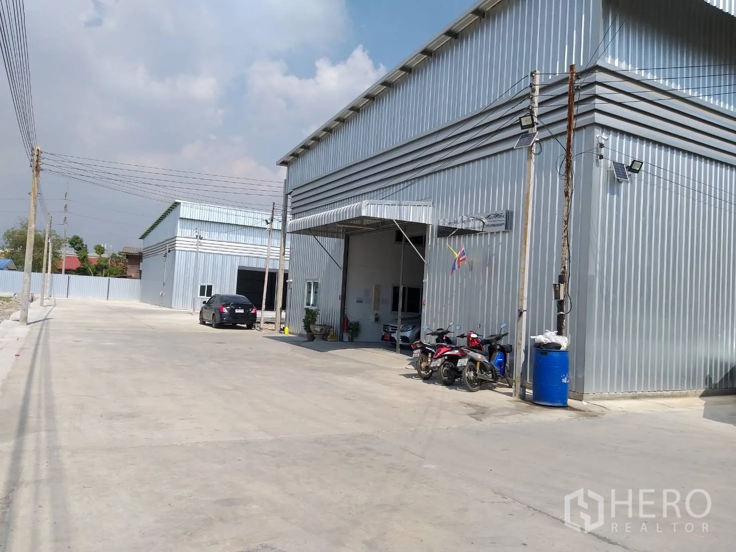 คลังสินค้า ให้เช่าในBang Phli, Samut Prakan - หน้าโกดังมีชายคาทางเข้าและพื้นที่จอดรถจักรยานยนต์