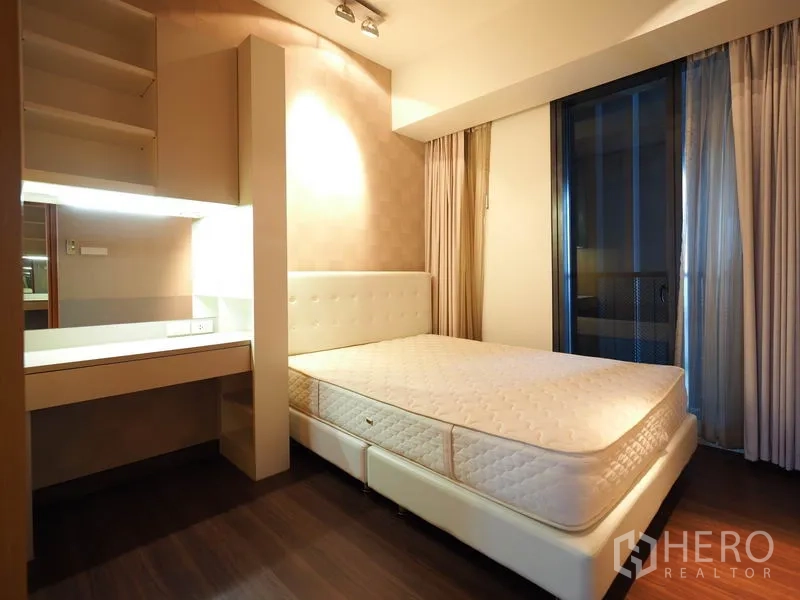 คอนโด ให้เช่าในSathon, Bangkok - ห้องนอนอบอุ่นเตียงควีน โต๊ะทำงาน และประตูกระจกบานเลื่อนไปยังระเบียง