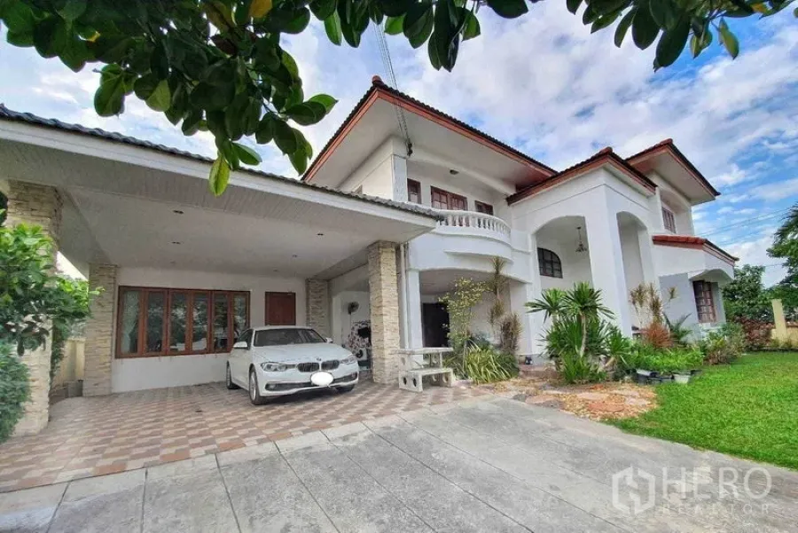 Detached House for sale in Taling Chan, Bangkok - Two-storey white detached house with carport and front lawn.