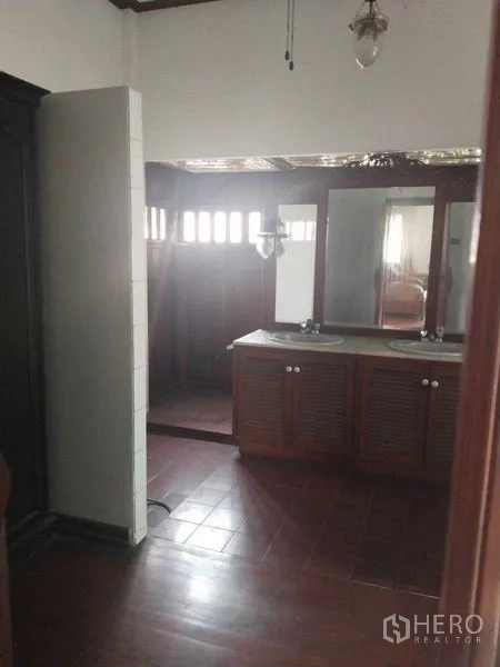 Detached House for rent or sale in Suan Luang, Bangkok - Bathroom with wooden cabinetry, double sinks, and a separate shower area.