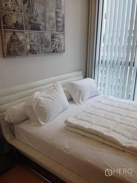 คอนโด ให้เช่าในWatthana, Bangkok - ห้องนอนปูผ้าปูสีขาว พร้อมมู่ลี่แนวตั้งข้างประตูระเบียง