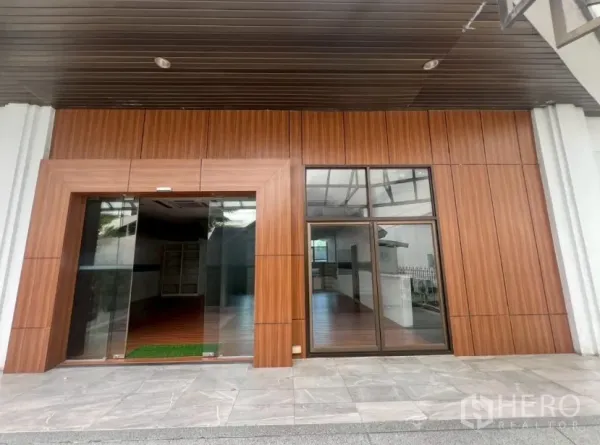 零售空间 出租 - 通罗商圈街铺外立面，木质饰面与大面积玻璃门窗，位于瓦他那区。