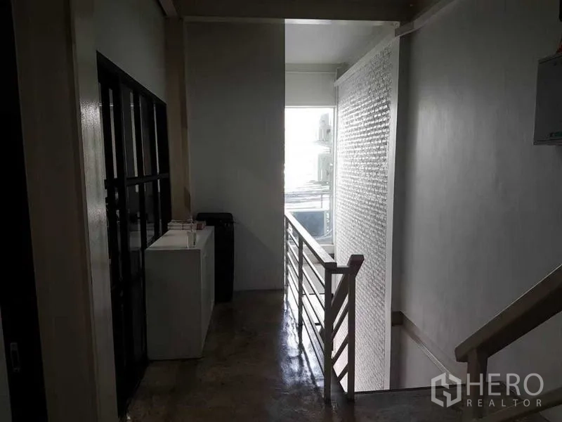 店屋 出售在Bang Rak, Bangkok - 楼梯平台采光充足，白墙与纹理装饰墙