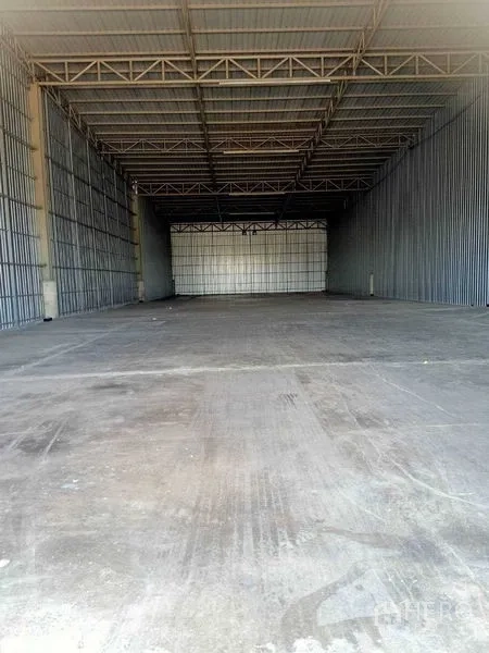 Warehouse for rent in Nong Suea, Pathum Thani - Spacious warehouse interior featuring a high ceiling, steel trusses, and smooth concrete floor.