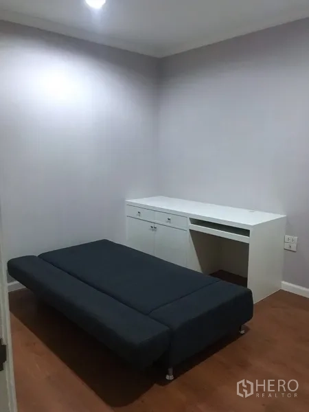 คอนโด ให้เช่าหรือขายในWatthana, Bangkok - ห้องอเนกประสงค์พร้อมโซฟาเบดและโต๊ะทำงานสีขาว พื้นไม้