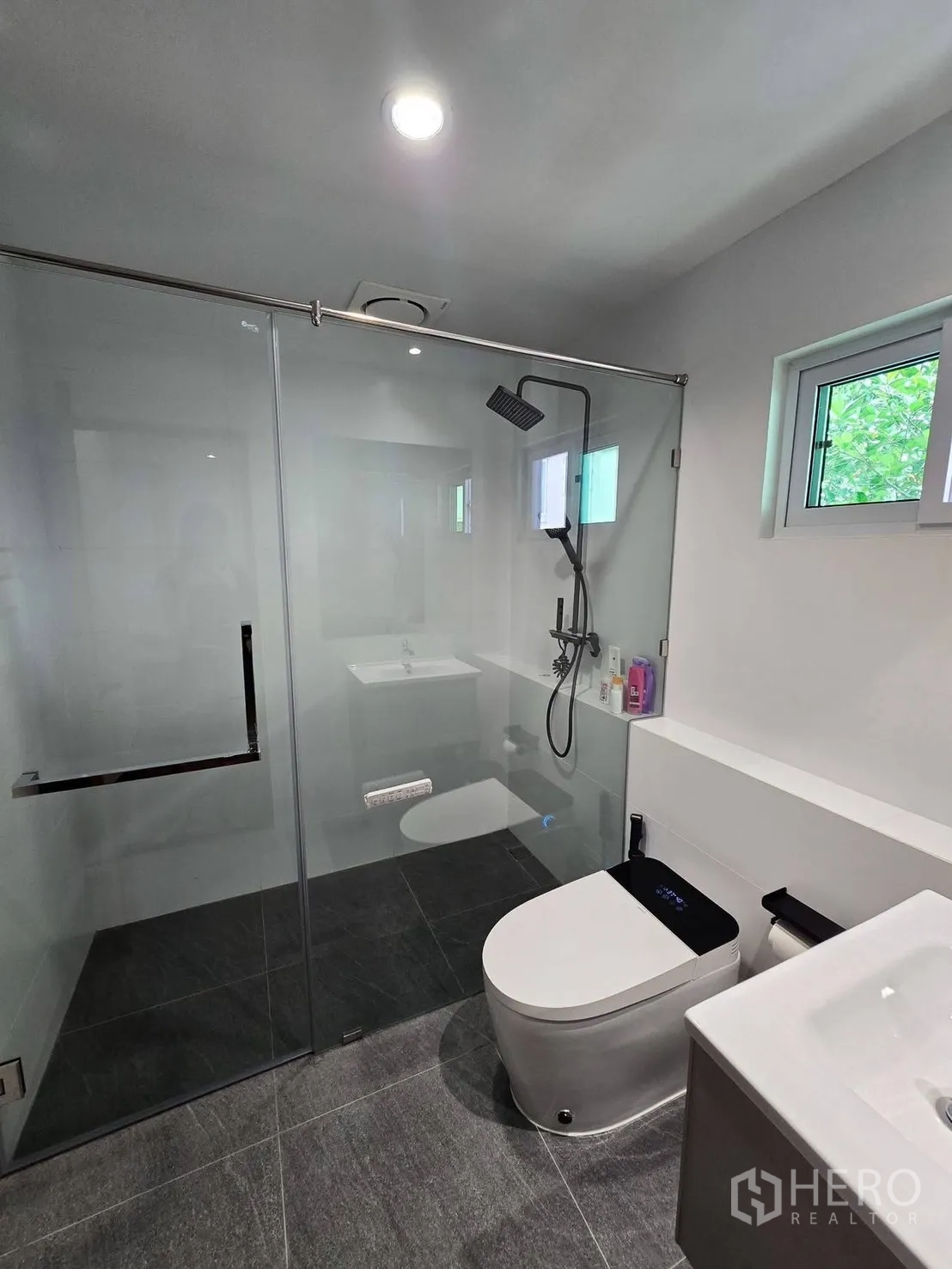 Detached House for rent in Suan Luang, Bangkok - Modern bathroom with glass-enclosed shower, smart toilet and vanity.