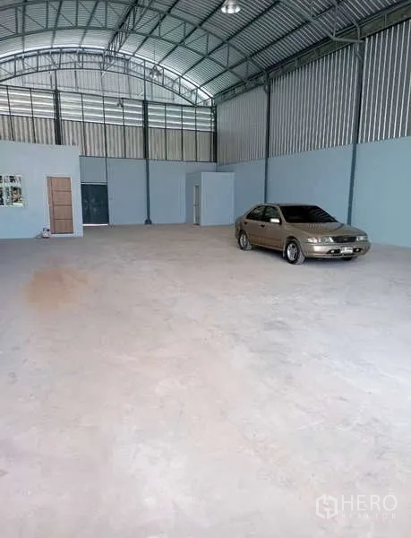 货栈 出租在Krathum Baen, Samut Sakhon - 仓库内部，高挑钢结构屋顶与平整混凝土地面，侧墙设有小型办公室与卫生间。