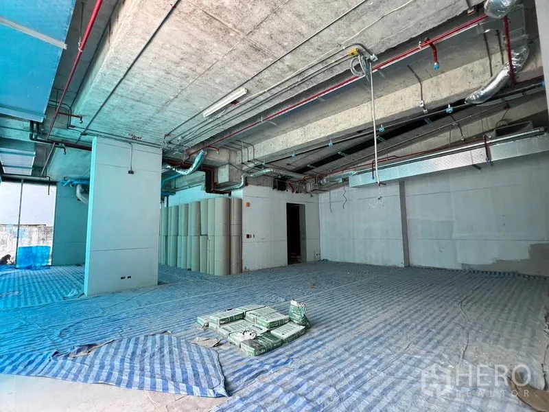 พื้นที่ขายปลีก ให้เช่าในKhlong Toei, Bangkok - พื้นที่ค้าปลีกแบบเปลือกอาคาร เพดานคอนกรีตเปลือย เดินท่อ และปูผ้าใบสีน้ำเงินบนพื้น
