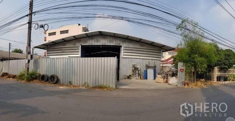 货栈 出租在Sai Mai, Bangkok - 曼谷沙迈区金属板仓库的街景，可见大门与车道入口。