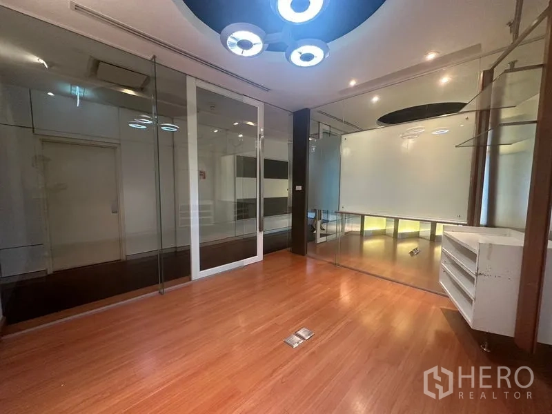 Office Space for rent in Khlong Toei, Bangkok - Glass-partitioned office with wood floors and contemporary circular lights.