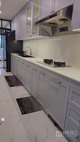 独立式住宅 出售在Sai Mai, Bangkok - 一字型厨房，白色台面，燃气灶与大理石纹地砖。