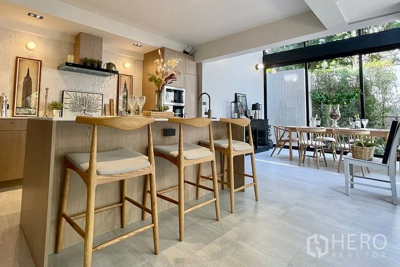 联排别墅 出售在Khlong Toei, Bangkok - 开放式厨房带吧台，衔接花园景观餐区。