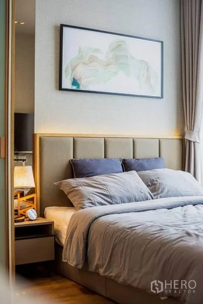 คอนโด ให้เช่าในWatthana, Bangkok - ห้องนอนบรรยากาศสงบ หัวเตียงบุผ้า ชุดเครื่องนอนครบ โต๊ะหัวเตียง และภาพตกแต่งผนัง