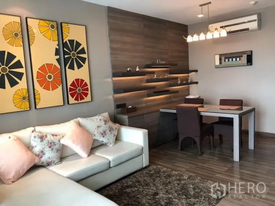 คอนโด ให้เช่าหรือขายในWatthana, Bangkok - ห้องนั่งเล่นเชื่อมรับประทานอาหาร โซฟาสีขาว ภาพศิลป์บนผนัง พื้นไม้ และชั้นไฟซ่อน