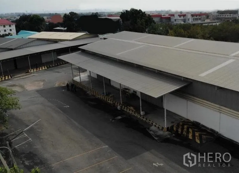 货栈 出租在Chon Buri - 带长形雨棚的仓库与宽阔回车场地，适合半挂车调头（是拉差）。