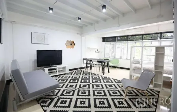 สำนักงานที่บ้าน ให้เช่าในKhlong Toei, Bangkok - ห้องนั่งเล่นกว้างพร้อมโซฟา ทีวี ชุดโต๊ะอาหาร และหน้าต่างบานใหญ่เหนือพรมลายขาวดำ