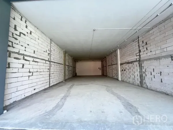 พื้นที่ขายปลีก ให้เช่า - พื้นที่ค้าปลีกเปล่า ยังไม่ตกแต่ง พื้นคอนกรีต ผนังบล็อกสีขาว เพดานเดินไฟ รูปแบบลึกทรงสี่เหลี่ยมผืนผ้า