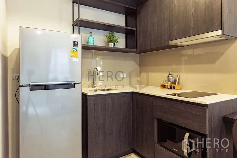 Condominium for rent or sale - L-shaped kitchenette with built-in hob, hood, sink and refrigerator.