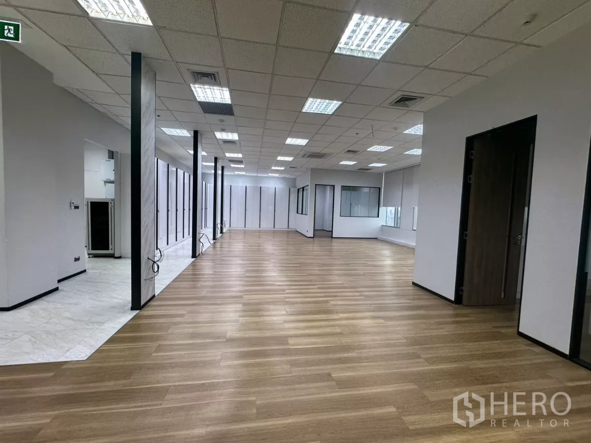 办公空间 出租在Watthana, Bangkok - 大面积办公楼层，木与石材通道、玻璃隔断及设备区。