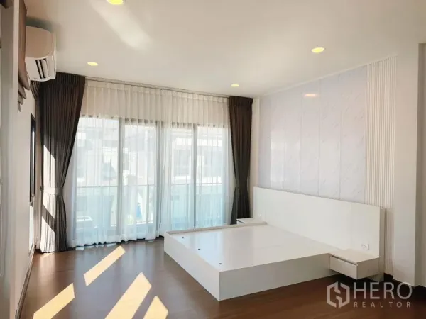 Detached House for rent in Bang Phli, Samut Prakan - Master bedroom with platform bed, sheer curtains and balcony doors.