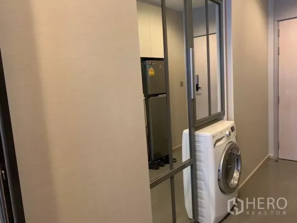 Condominium for rent or sale in Watthana, Bangkok - Entry corridor featuring mirrored closet doors and a front-loading washing machine.